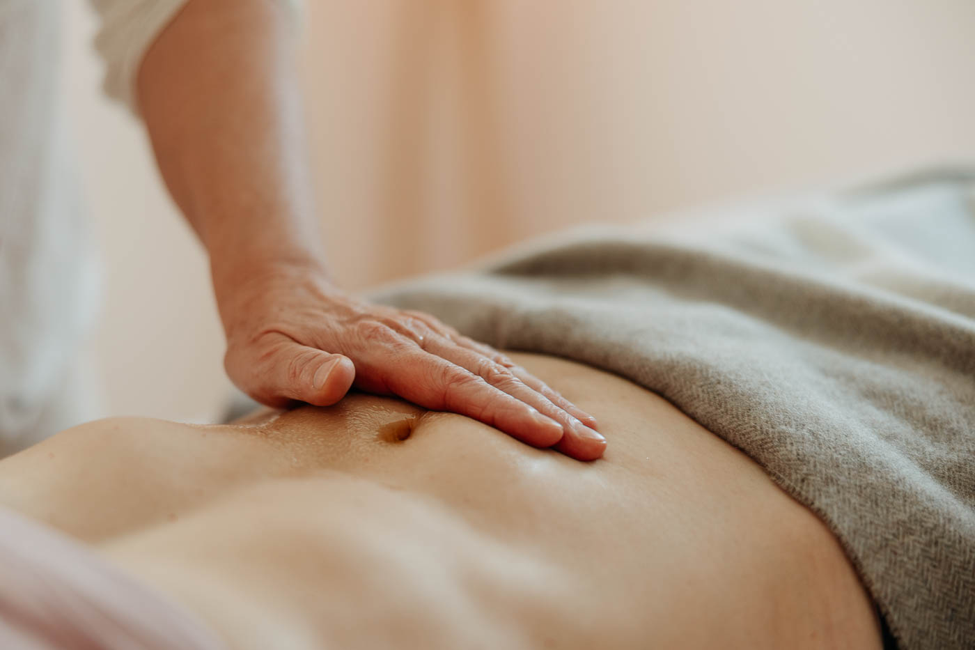 Eine Hand liegt auf einem Bauch für eine Massage