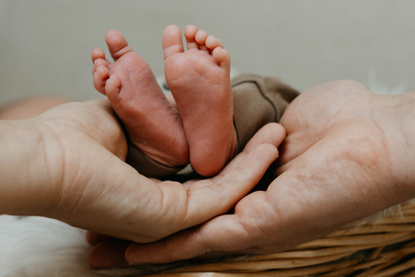 Zwei Hände halten sanft zwei Babyfüsse